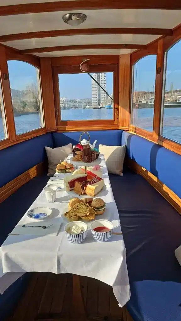 Cabine de bateau canal avec buffet High Tea végane et vue panoramique sur Amsterdam